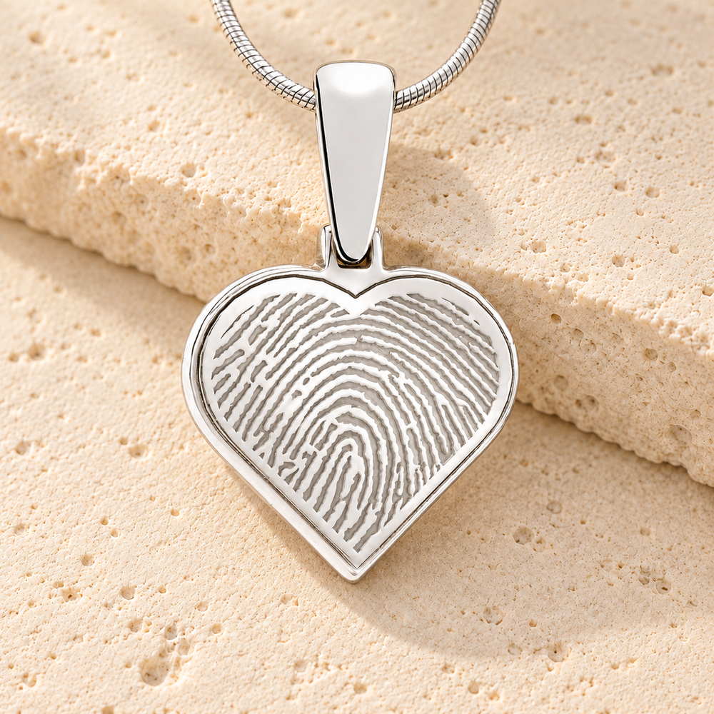 Silver heart fingerprint pendant with original bail and silver chain on cream stone