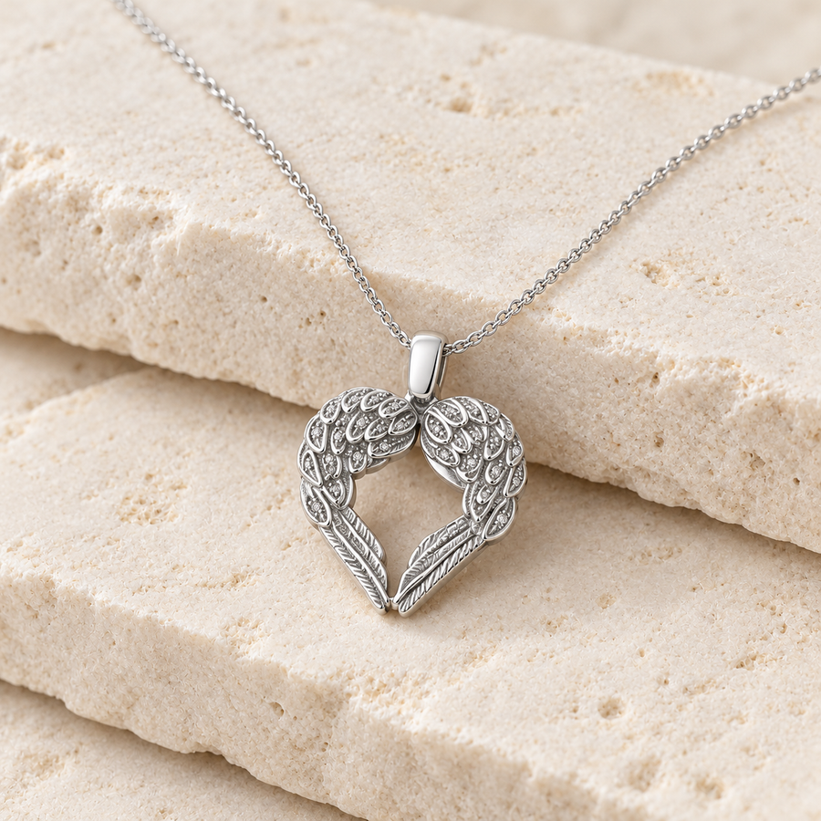 Silver winged heart cremation necklace on cream stone.